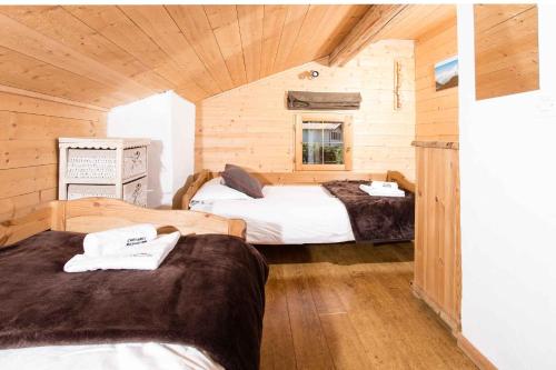 a room with two beds in a log cabin at Les Pelerins Apartment - Chamonix All Year in Chamonix