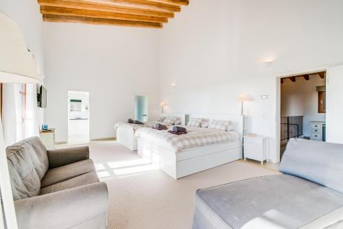 a living room with white furniture and a couch at Finca Mar des Teix in Manacor