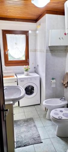 a bathroom with a washing machine and a sink at Casa della Mamma in Antey-Saint-André