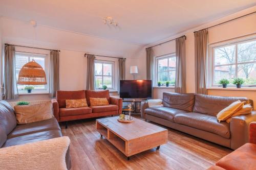 a living room with leather couches and a coffee table at Noorderzon in Buren