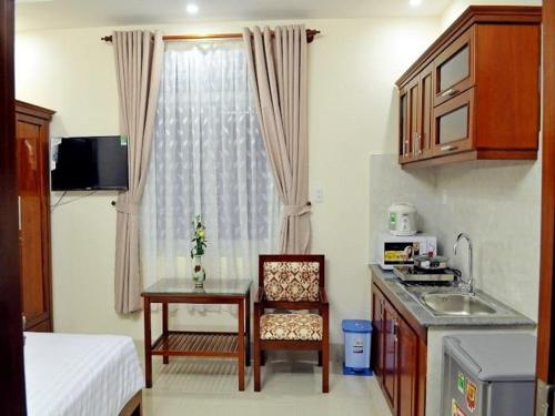 a kitchen with a table and a sink in a room at Lotus Apartment Hotel in Vung Tau