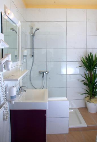 a bathroom with a sink and a shower and a tub at Hotel Drescher in Mörbisch am See