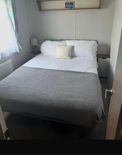 a bed with a pillow on it in a bedroom at Haven Holiday Park Perran Sands in Perranporth