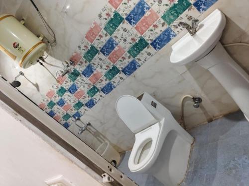 un baño con inodoro y lavabo en HOTEL SQUARE INN Cosmopolitan, en Bangalore