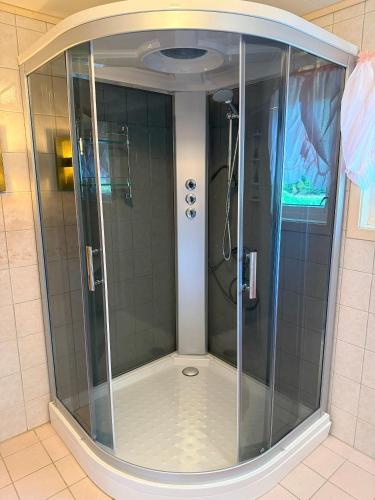 a shower with a glass door in a bathroom at Great House with a panoramic view in Storsæter