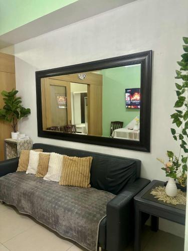 a living room with a couch and a large mirror at Shell Residence Pasay City in Manila