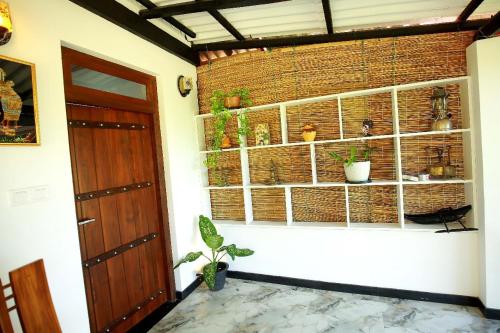 Una habitación con una ventana con plantas y una puerta. en Lisky Villa Blue Beach Hiriketiya, en Dikwella