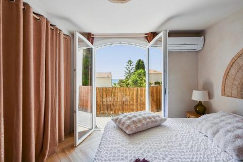 a bedroom with a bed and a large window at De l'élégance au bord de l'eau in La Ciotat