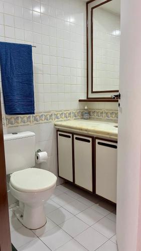 une salle de bain avec toilettes, lavabo et miroir dans l'établissement Flat Pituba Sol - conforto e ótima localização, à Salvador