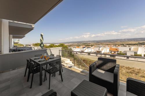 a patio with a table and chairs on a balcony at Atlantic Panoramic Villa in Salir de Porto