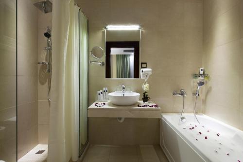 une salle de bain avec un lavabo, une douche et une baignoire dans l'établissement شقق لمار الغرب الفاخرة, à Djeddah