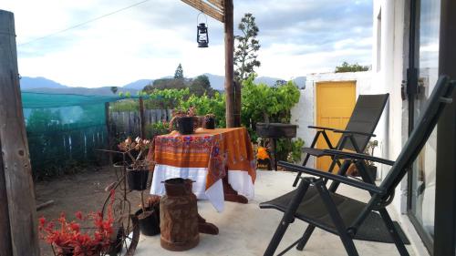 a table and a chair on a patio at The Anvil Rest Cottage in Calitzdorp