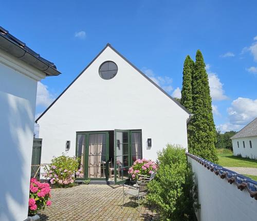 a white house with a patio and a fence at Luxury Guesthouse, 30 min from Copenhagen in Stenløse