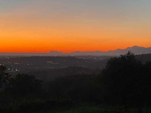 a sunset over a city with mountains in the background at La Rosa di Tempalta in Roccadaspide