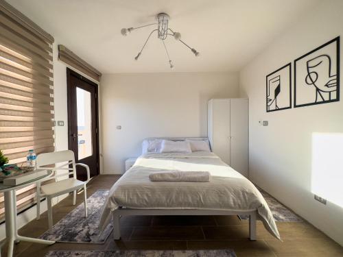 a bedroom with a bed and a table and a desk at 33A4. Rooftop Studio w Terrace Green Views in Sheikh Zayed