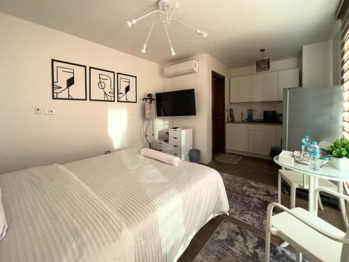 une chambre avec un lit, une table et une télévision dans l'établissement 33A4. Rooftop Studio w Terrace Green Views, à Sheikh Zayed