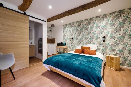 a bedroom with a large bed with a blue blanket at Les tuiles bourguignonnes in Fontaine-lès-Dijon