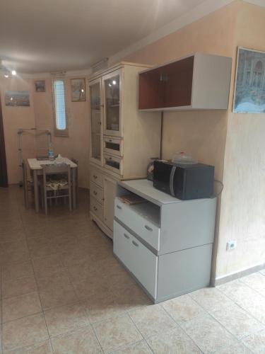 a kitchen with a counter with a microwave and a table at My Nest in Arzachena