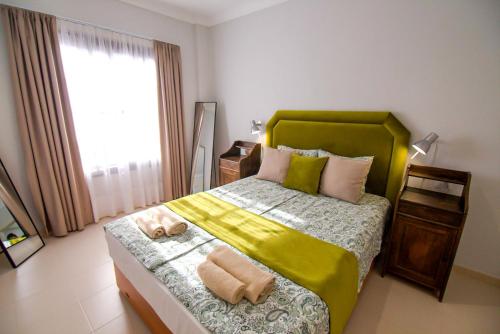 1 dormitorio con 1 cama verde y 2 toallas en Bacon del Mar Apartment, en Costa del Silencio