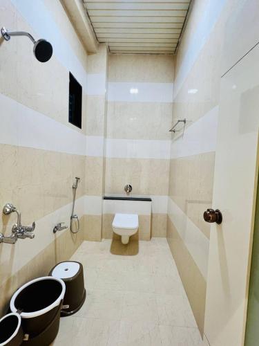 a bathroom with a toilet and a sink at Hotel Apple in Phardāpur