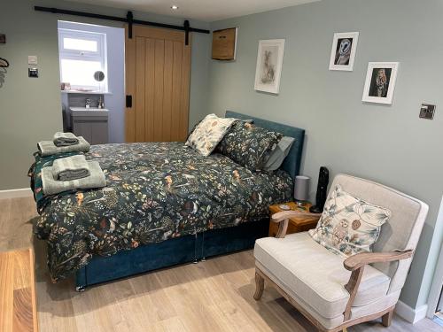 a bedroom with a bed and a chair at Woodland View in East Harling