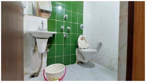 a green and white bathroom with a toilet and a sink at Hotel Park-Resort Bhubaneshwar Near Railway Station - A Premium Hotel Lift Facilites And Parking ,wifi - Fully Air Conditioning Luxury Room in Cuttack