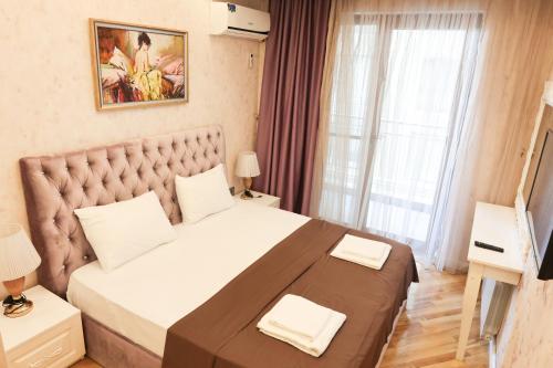 una camera da letto con un letto grande con una grande finestra di Azur 11 a Baku