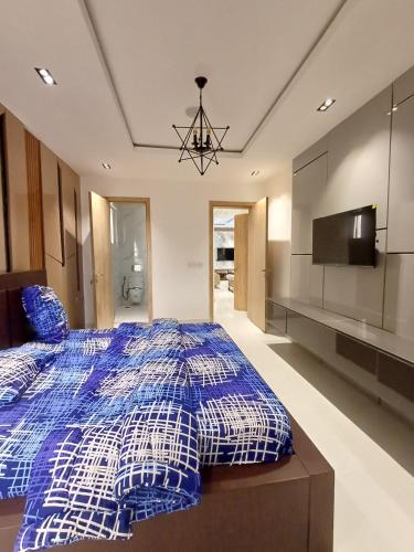 1 dormitorio con 1 cama azul y blanca y TV en Horyn Homes, en Lekki