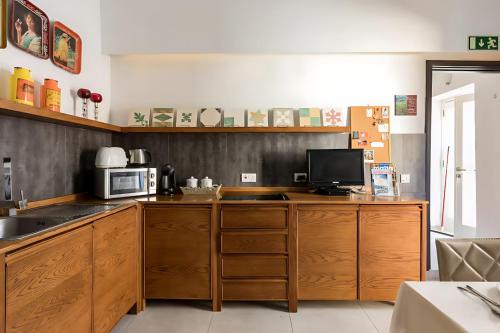 バレッタにあるMagic romantic escape in the heart of Vallettaのキッチン(木製キャビネット、電子レンジ付)