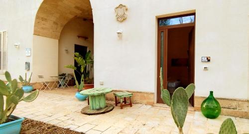 a patio with a table and some plants at Salento Houses & Idro Suites in Nardò