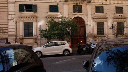 Un coche blanco aparcado delante de un edificio en La dolce Silla - Appartamenti al Vaticano,Via Silla 91, en Roma