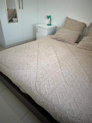 a bedroom with a bed with a white bedspread at Dwellers Double in Grassy Park