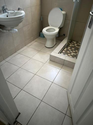 a bathroom with a toilet and a sink at Dwellers Double in Grassy Park