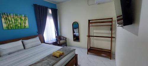 Un dormitorio con una cama con una pared azul. en Mentari Homestay, en Sentool