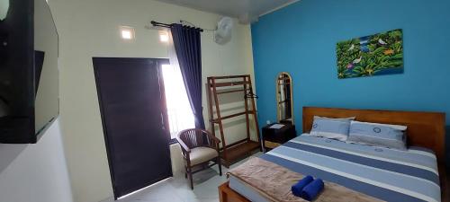 Un dormitorio con una cama con una pared azul. en Mentari Homestay, en Sentool