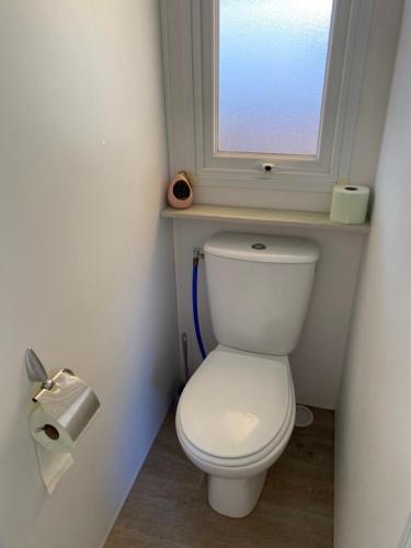 a white toilet in a bathroom with a window at La Parenthèse in Sérignan