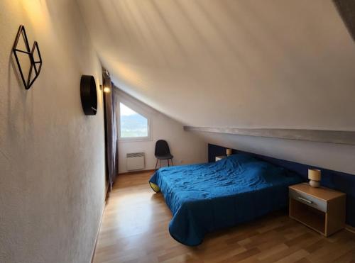 a bedroom with a blue bed in a attic at maison in Le Thillot