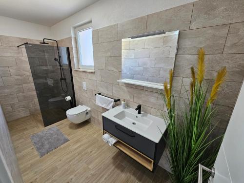 a bathroom with a sink and a shower and a toilet at Villa Maestro in Sreser