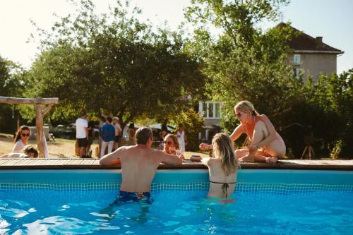 a group of people sitting in a swimming pool at Le Pavillon, Grand Manoir du XVIIe avec Piscine, Bain Nordique et accès privé à la Charente in Alloué