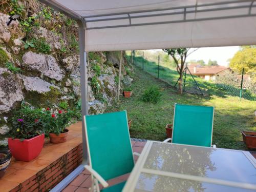 a table and chairs on a patio with a stone wall at El jardín de Max in Comillas