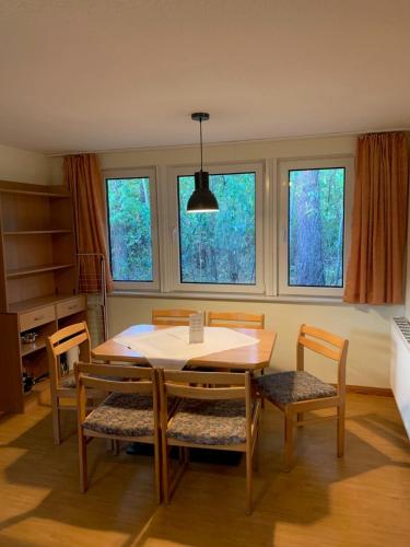 a dining room with a table and chairs and windows at martas Gästehäuser Groß Väter See in Templin
