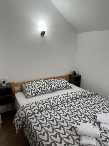 a bedroom with a bed with a black and white comforter at Apartmani Rajić, Tara in Kaludjerske Bare