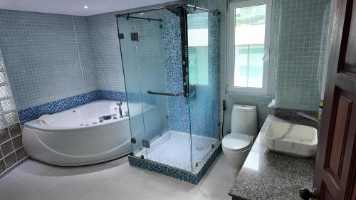 a bathroom with a tub and a shower and a toilet at Modern apartment in Patong Center in Ban Nong Chaeng