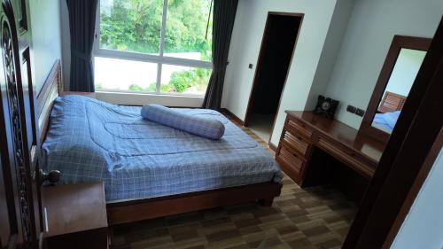 a bedroom with a bed and a dresser and a mirror at Modern apartment in Patong Center in Ban Nong Chaeng