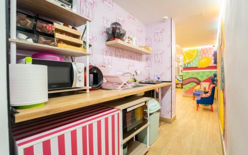 a kitchen with pink walls and a counter with a microwave at Lemon & Green GuestHouse in Granada