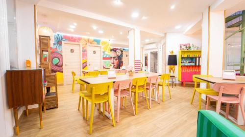 a dining room with tables and yellow chairs at Lemon & Green GuestHome in Granada