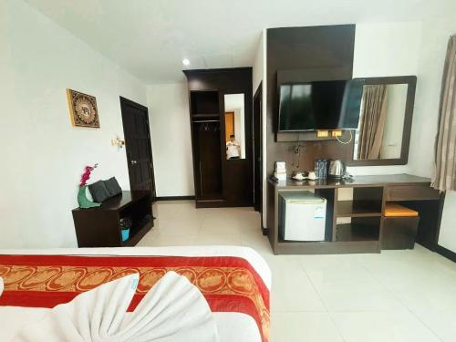 a hotel room with a bed and a flat screen tv at Abby's House Hotel in Patong Beach