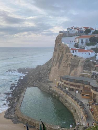a large pool of water on a cliff next to the ocean at Azenhas do Mar Valley House in Sintra
