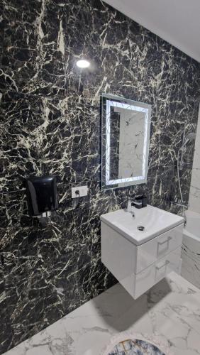 a bathroom with a sink and a mirror on a wall at Apartament EVA in Suceava