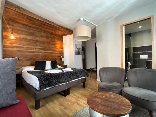 a bedroom with a bed and a table and chairs at Auberge de la Paix in Briançon